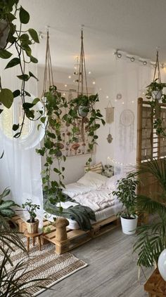 a room filled with lots of plants next to a bed