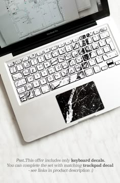 an open laptop computer sitting on top of a white table next to a mouse and keyboard