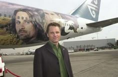 a man standing in front of an airplane with the image of jesus painted on it