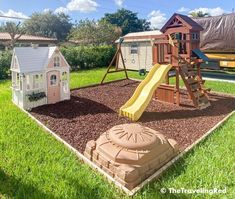 a play set in the middle of a yard with a slide and house on it