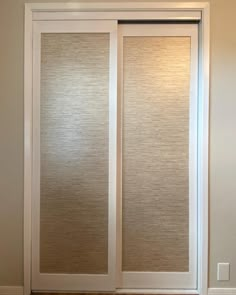 a sliding glass door in a room with white walls and wood flooring on the side