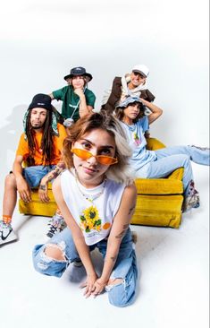 a group of young people sitting on top of a yellow couch next to each other