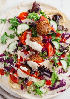 a pita filled with vegetables and meatballs