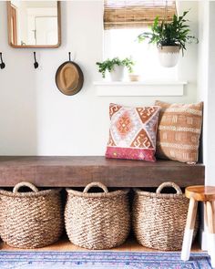 a bench with baskets and plants on it in front of a mirror, potted plant