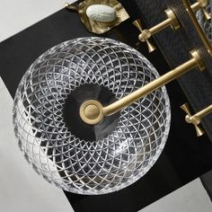 a clear glass bowl sitting on top of a black table next to a gold handle