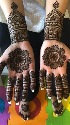 two hands with henna designs on them