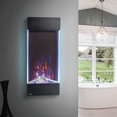 a wall mounted fire place next to a bathtub with a window in the background