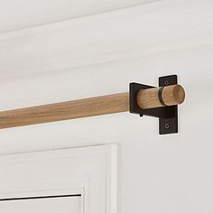 a close up of a door handle with a wooden bar on the front and side