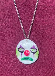 a necklace with a clown face painted on it