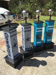 three football trophies sitting on top of each other in front of a white car and trees