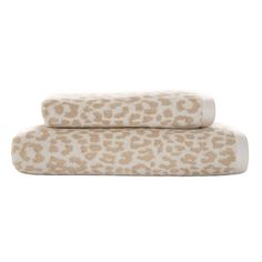 two leopard print towels on top of each other in white and tan colors, one with brown spots