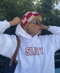 a woman wearing sunglasses and a white hoodie with the word stay written on it