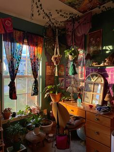 a room filled with lots of plants next to a window covered in curtains and potted plants