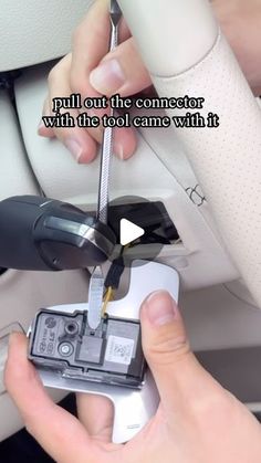 someone is pulling out the connectors from their car radio to connect with the camera