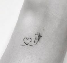 a small tattoo with two hearts and a butterfly on the side of the arm,