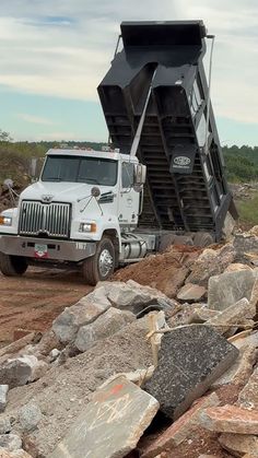 a dump truck parked on top of a pile of rocks