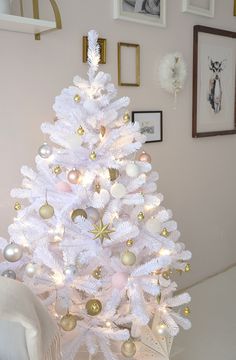 a white christmas tree with gold and silver ornaments