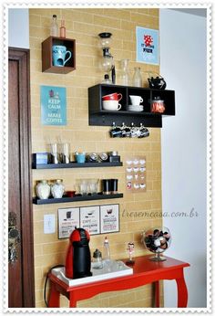 there is a red table and shelves on the wall with coffee mugs in them