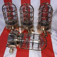 four glass and metal containers sitting on top of a red and white striped table cloth