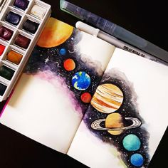 an artist's notebook with watercolors and pens on it, containing the planets