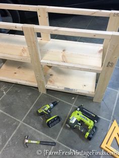 some tools are laying on the floor next to a shelf that is made out of plywood