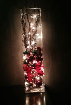 a glass vase filled with ornaments and lights