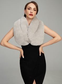 a woman in a black dress with a fur stole around her neck and hands on her hips