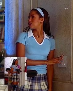 a woman in a blue shirt and plaid skirt standing next to a wall with two pictures on it