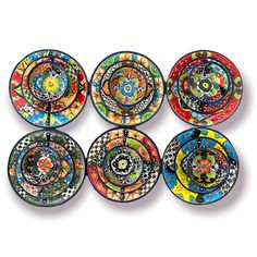 six colorful plates with designs on them are arranged in a row and one is empty