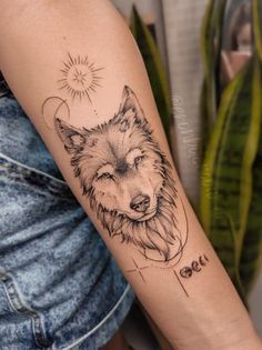 a woman's arm with a wolf tattoo on it