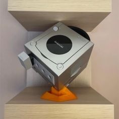 an electronic device sitting on top of a wooden shelf