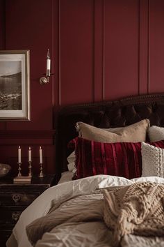 a bed with red walls and white linens in a room that has been painted maroon