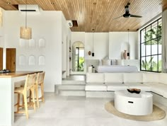 a living room filled with white furniture and lots of windows