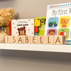 a teddy bear sitting on top of a book shelf next to some children's books