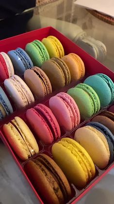 a red box filled with lots of different colored macaroons