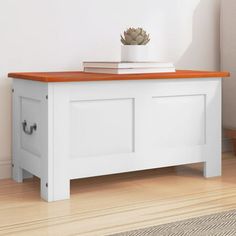 a white bench with an orange top in front of a wall and rug on the floor