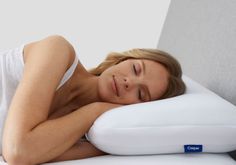 a woman laying on top of a white pillow