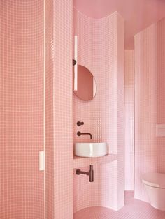 a bathroom with pink walls and floor tiles