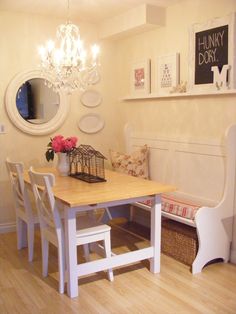 a dining room table with four chairs and a bench in front of a mirror on the wall