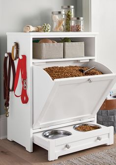 a white cabinet with drawers and two bowls in it next to a rug on the floor