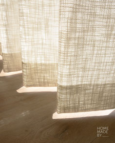 the curtains are open in the sunlight on the wood flooring area with light coming through them