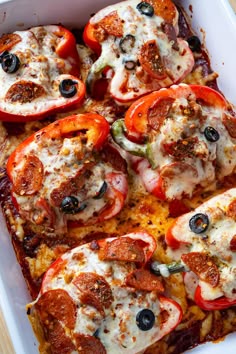 a casserole dish with tomatoes, olives, and mozzarella cheese