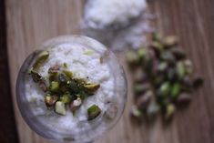 rice and pistachios in a glass on a wooden table