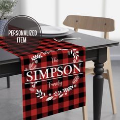 a table with a red and black plaid table runner on it that says, personalized item