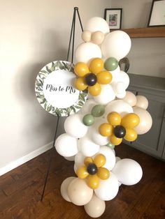 a bunch of balloons that are in the shape of flowers on a stand next to a wall