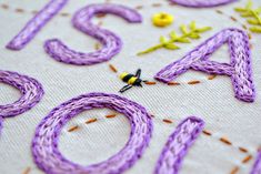 a close up of the letters and numbers made out of yarn on a piece of cloth