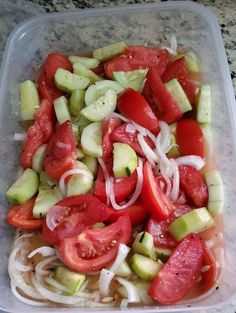 a plastic container filled with sliced tomatoes and cucumbers