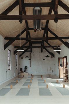 an empty room with wooden beams and white tile flooring is seen in this image