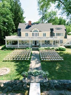 an outdoor wedding venue with rows of chairs set up in front of the main house