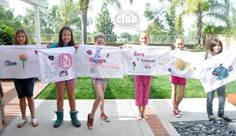 four girls holding up their t - shirts in front of the camera